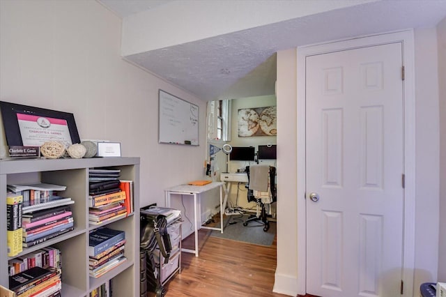 home office featuring wood-type flooring and a textured ceiling