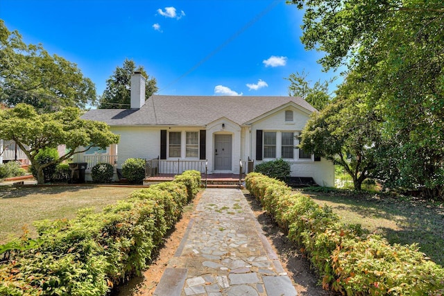 ranch-style house with a front yard and covered porch