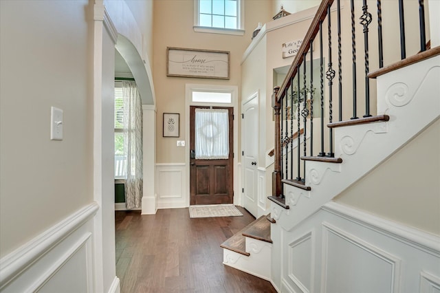 714 Neville St, Grovetown, GA 30813 - foyer with a decorative wall, arched walkways, a wainscoted wall, dark wood-style flooring, and stairway