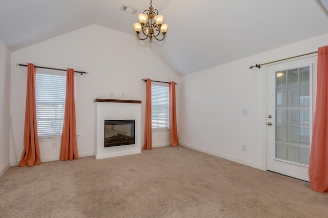 unfurnished living room with visible vents, carpet, lofted ceiling, an inviting chandelier, and a glass covered fireplace