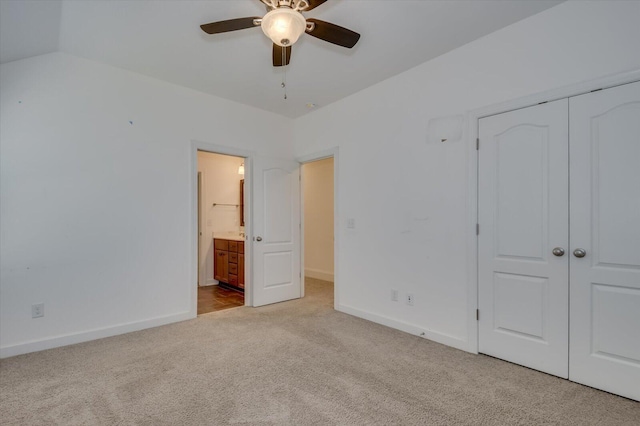 unfurnished bedroom with a closet, carpet flooring, ensuite bath, and baseboards