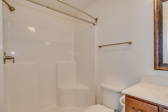 bathroom featuring toilet, walk in shower, and vanity