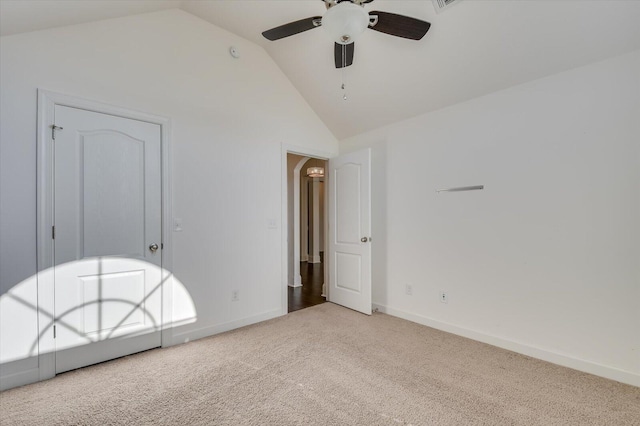 unfurnished bedroom with carpet flooring, ceiling fan, baseboards, and vaulted ceiling