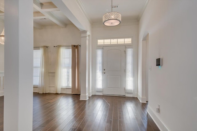 entrance foyer with beam ceiling, dark wood-style floors, baseboards, and ornate columns