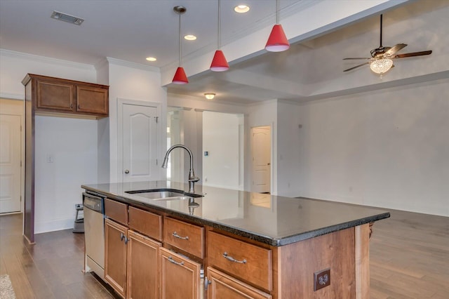 kitchen with brown cabinetry, visible vents, dark wood finished floors, a sink, and crown molding