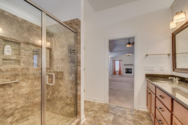 full bath with vanity, a shower stall, a fireplace, and ceiling fan