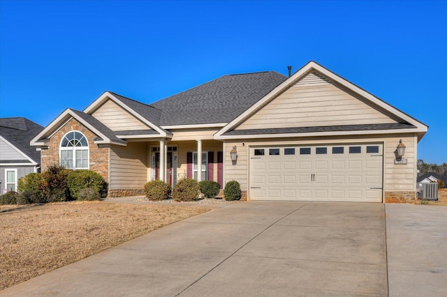 view of front of house with a garage, central air condition unit, driveway, and a shingled roof