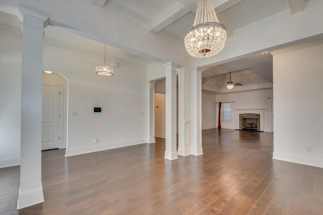 unfurnished living room with a ceiling fan, ornate columns, a fireplace, dark wood-type flooring, and beamed ceiling