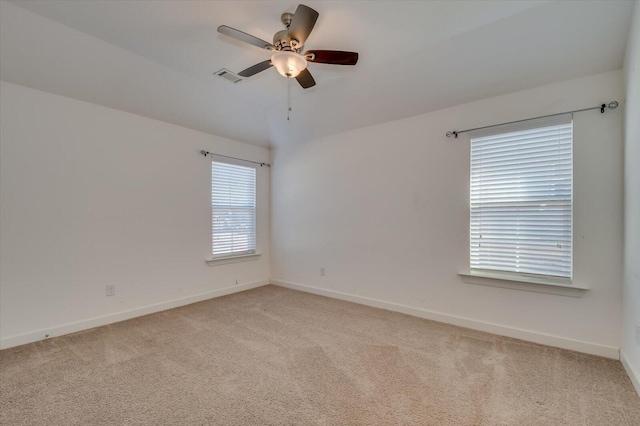 empty room featuring visible vents, baseboards, light colored carpet, and ceiling fan