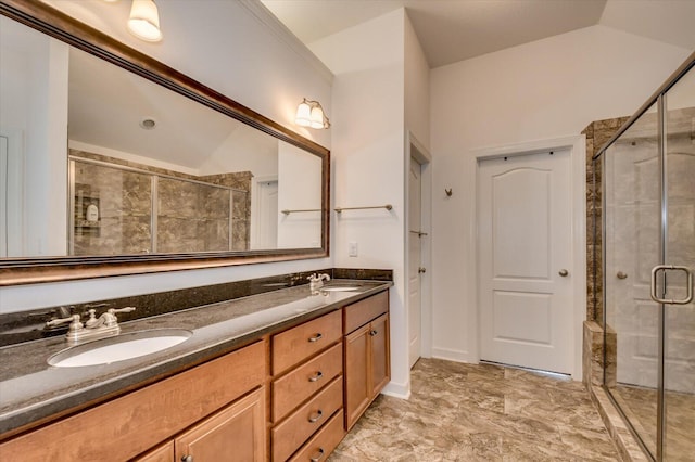 full bath featuring a sink, lofted ceiling, a stall shower, and double vanity