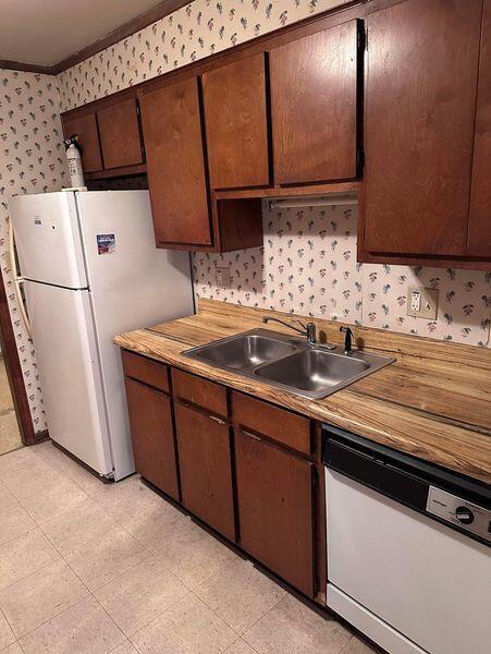 kitchen with crown molding, sink, and white appliances