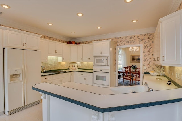 kitchen featuring backsplash, kitchen peninsula, crown molding, white appliances, and white cabinets