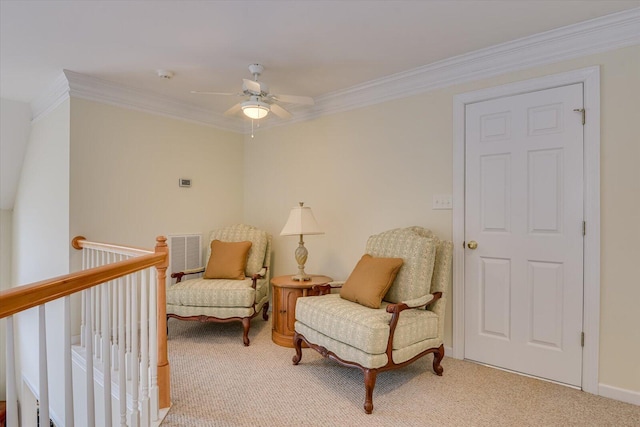 living area featuring carpet, ceiling fan, and crown molding