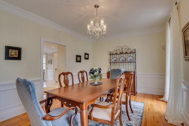 dining room featuring a notable chandelier, light hardwood / wood-style floors, and ornamental molding