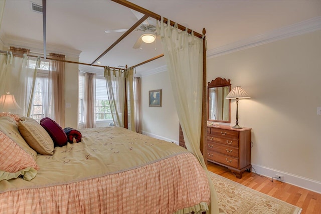 bedroom featuring light wood-type flooring, ceiling fan, and crown molding