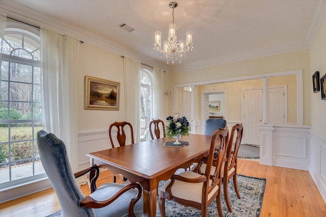 dining room with a chandelier, crown molding, plenty of natural light, and light hardwood / wood-style floors