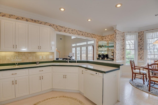 kitchen featuring dishwasher, kitchen peninsula, white cabinetry, and crown molding