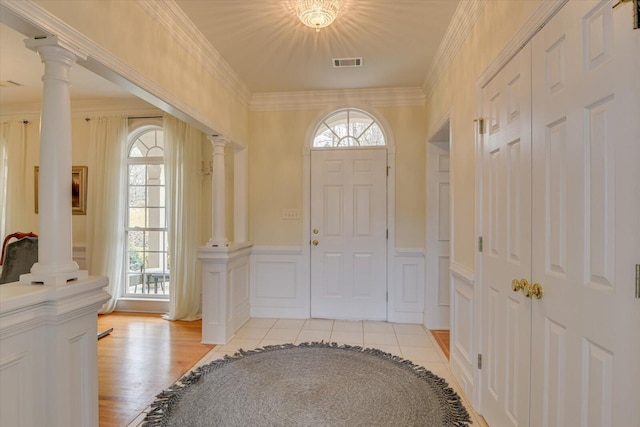 entryway with light tile patterned floors, ornate columns, and plenty of natural light