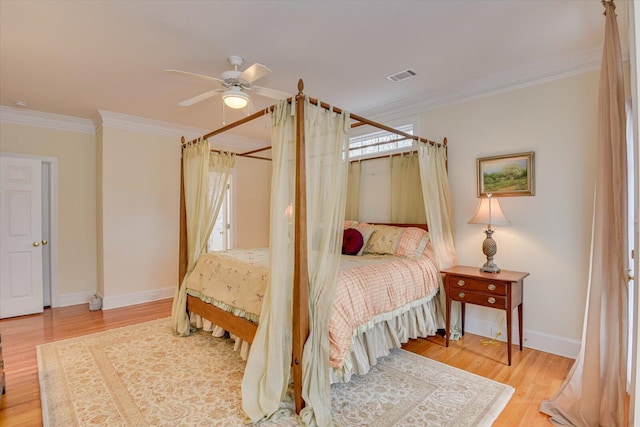 bedroom with multiple windows, ceiling fan, crown molding, and hardwood / wood-style flooring