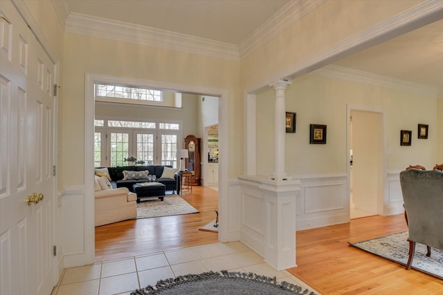 tiled entrance foyer with french doors, ornate columns, and ornamental molding