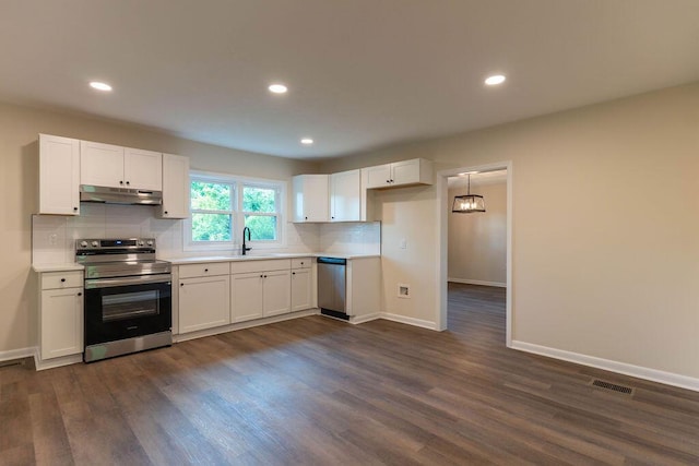 2011 Kennedy Dr, Augusta, GA 30904 - kitchen featuring appliances with stainless steel finishes, under cabinet range hood, backsplash, white cabinetry, and dark wood-style flooring