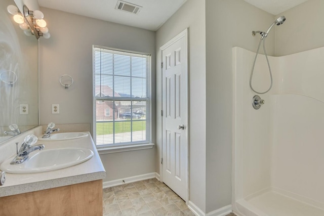 bathroom featuring a shower and vanity