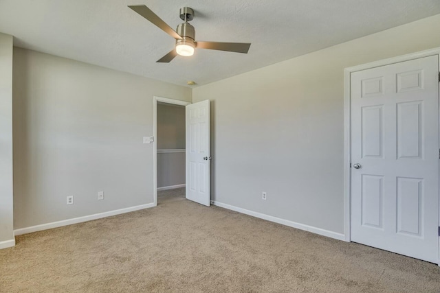 empty room with ceiling fan and light colored carpet