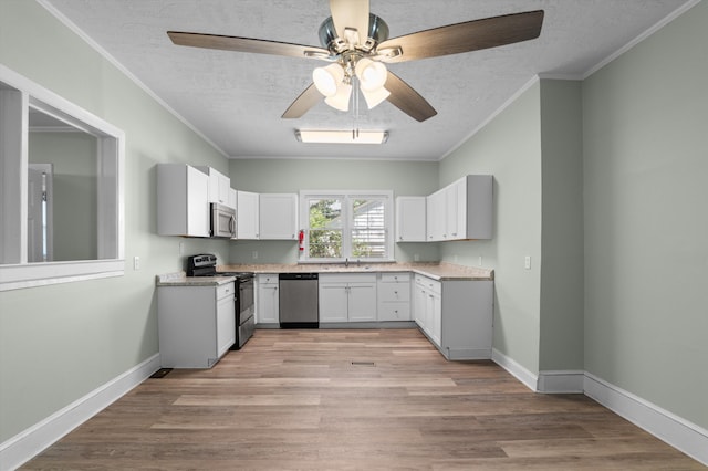 1940 Telfair St, Augusta, GA 30904 - kitchen with appliances with stainless steel finishes, a sink, a ceiling fan, ornamental molding, and a textured ceiling