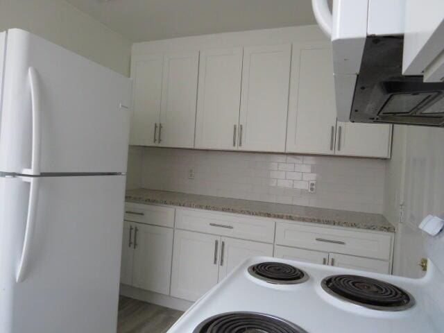 2480 Miles Ave, Augusta, GA 30906 - kitchen featuring freestanding refrigerator, extractor fan, white cabinetry, and tasteful backsplash