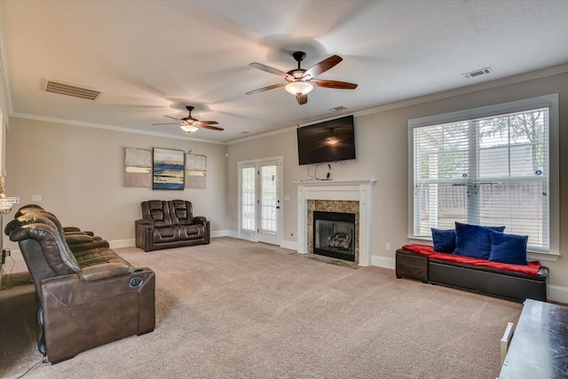 carpeted living room with a fireplace, plenty of natural light, and ornamental molding