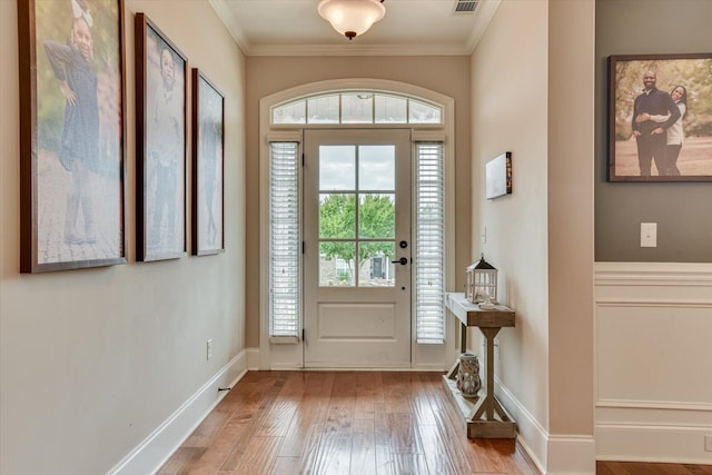 entryway with light hardwood / wood-style floors and ornamental molding