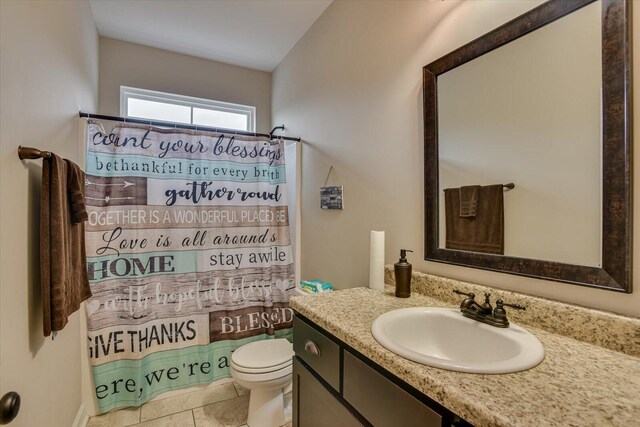 bathroom featuring toilet, a shower with curtain, vanity, and tile patterned floors