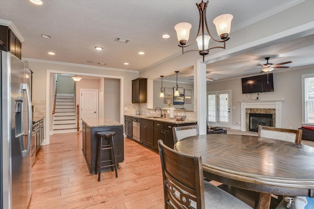 dining area with light hardwood / wood-style floors, sink, a fireplace, and a wealth of natural light