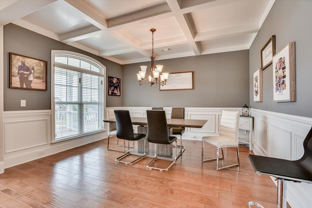 dining room with beamed ceiling, a chandelier, coffered ceiling, and light wood-type flooring