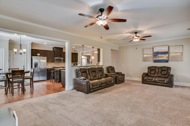 carpeted living room with ceiling fan with notable chandelier and ornamental molding