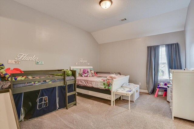 carpeted bedroom with a textured ceiling and lofted ceiling