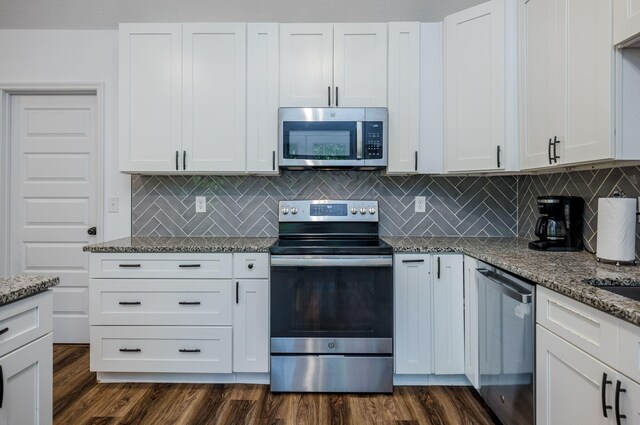 kitchen featuring tasteful backsplash, white cabinetry, light stone countertops, and stainless steel appliances