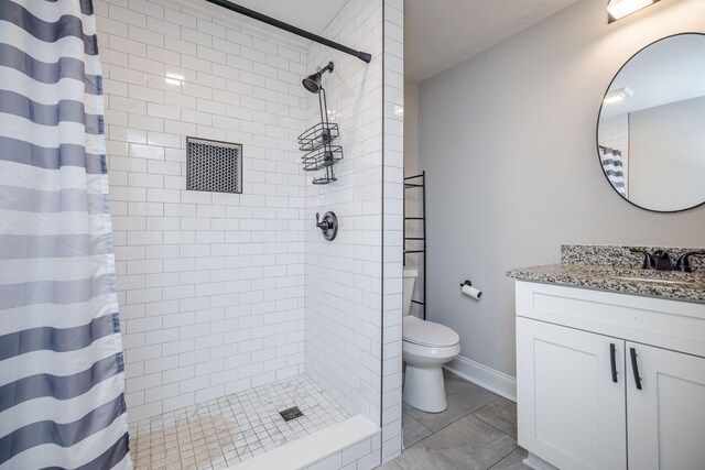 bathroom with toilet, tile patterned flooring, vanity, and walk in shower