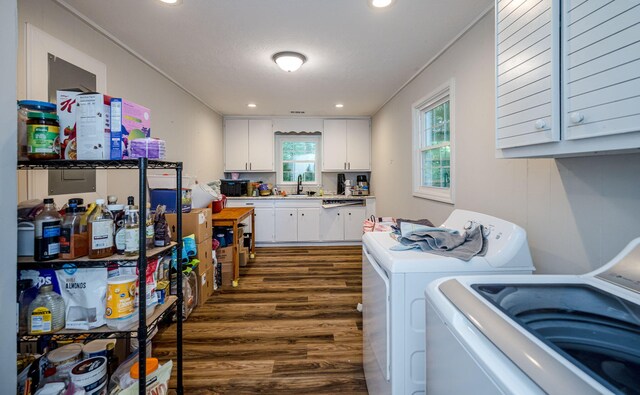 clothes washing area featuring sink, dark hardwood / wood-style flooring, crown molding, and washing machine and clothes dryer