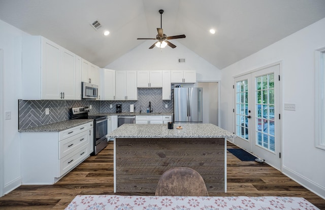 kitchen with appliances with stainless steel finishes, backsplash, french doors, ceiling fan, and white cabinets