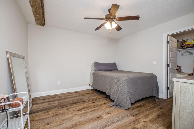 bedroom featuring hardwood / wood-style floors, ceiling fan, a walk in closet, and a closet