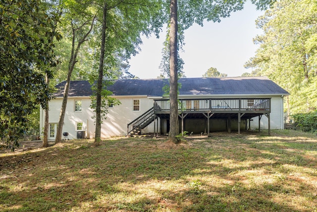 back of property featuring central air condition unit, a wooden deck, and a yard