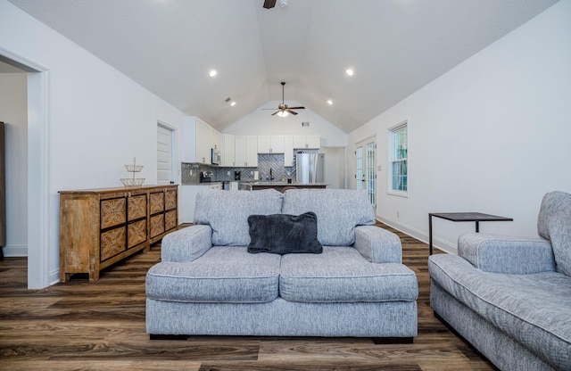 living room with ceiling fan, dark hardwood / wood-style floors, and vaulted ceiling