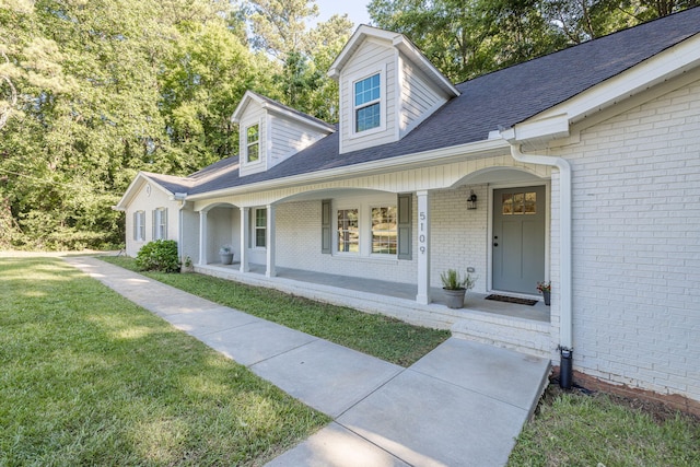 cape cod-style house with a front yard and a porch