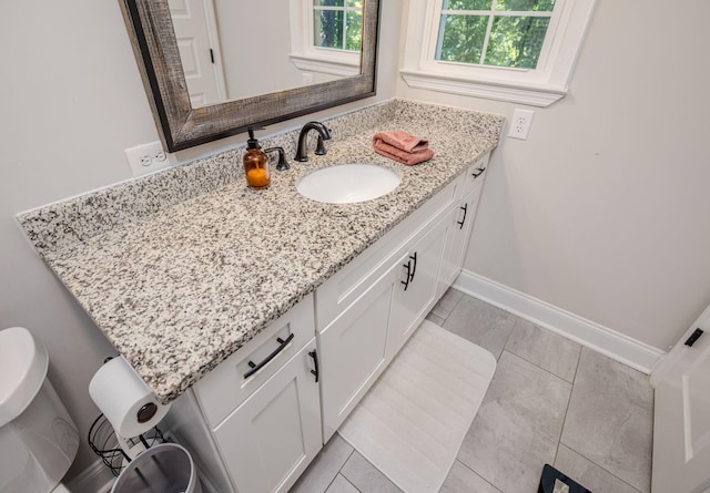 bathroom with tile patterned flooring, vanity, and toilet