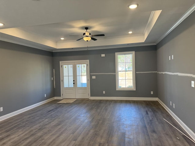 interior space featuring baseboards, ornamental molding, french doors, a tray ceiling, and dark wood finished floors