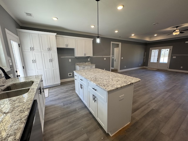 kitchen with dark wood finished floors, white cabinetry, a sink, and baseboards