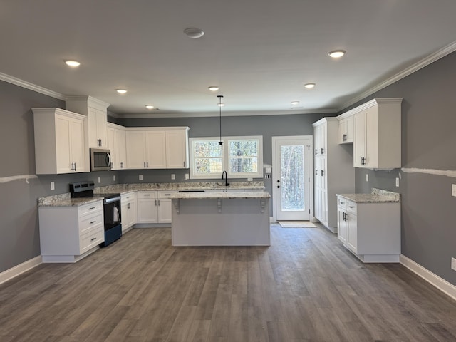 kitchen featuring electric range, baseboards, white cabinets, stainless steel microwave, and crown molding