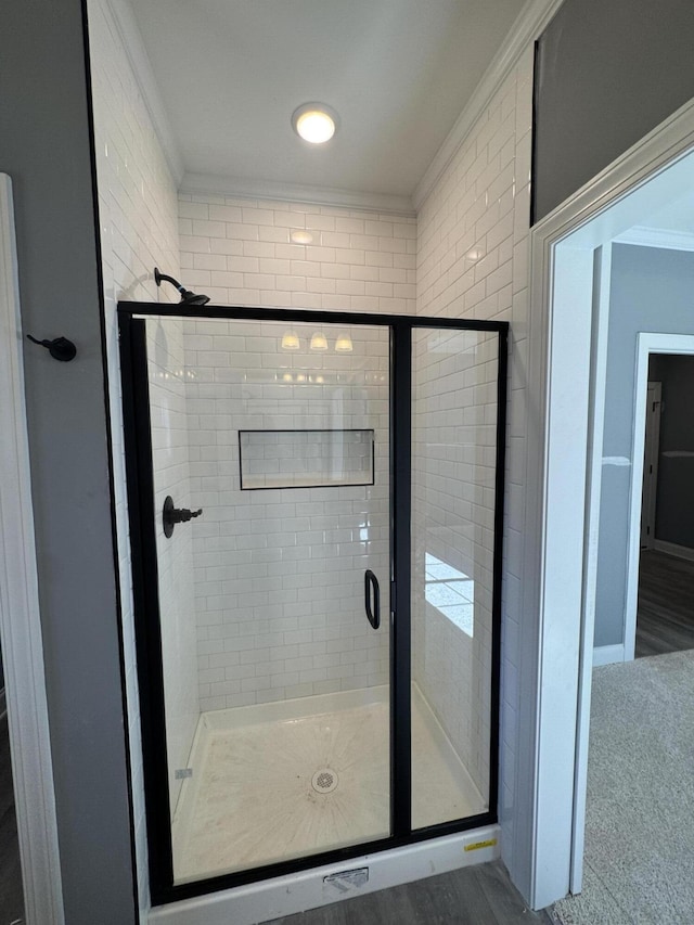 full bathroom with a stall shower and crown molding