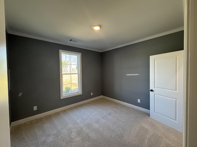 carpeted empty room featuring crown molding, visible vents, and baseboards